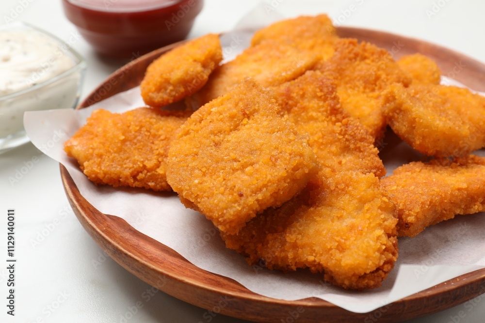 Tasty chicken nuggets on white table, closeup Tasty chicken nuggets on white table, closeup