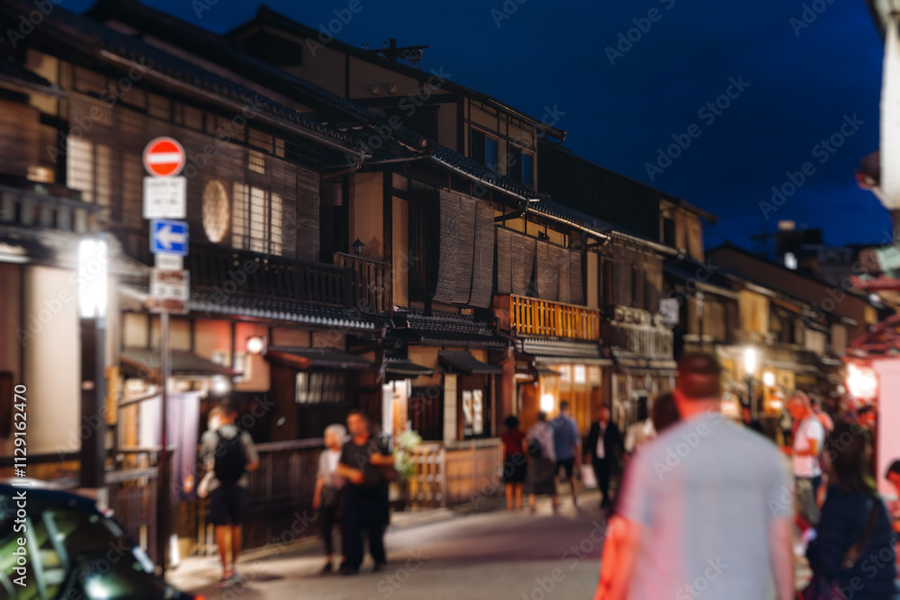 Fototapeta premium View of Gion district street, Kyoto, Higashiyama-ku, Japan, night illumination of Ninnenzaka and Sannenzaka streets, with old wooden tea houses Hokanji temple and Yasaka Pagoda, Gion geisha quarter