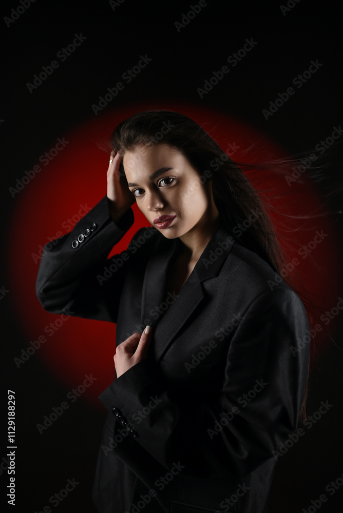 Beautiful girl in a black oversized blazer and red tights posing on a dark background. Beautiful girl in a black oversized blazer and red tights posing on a dark background.