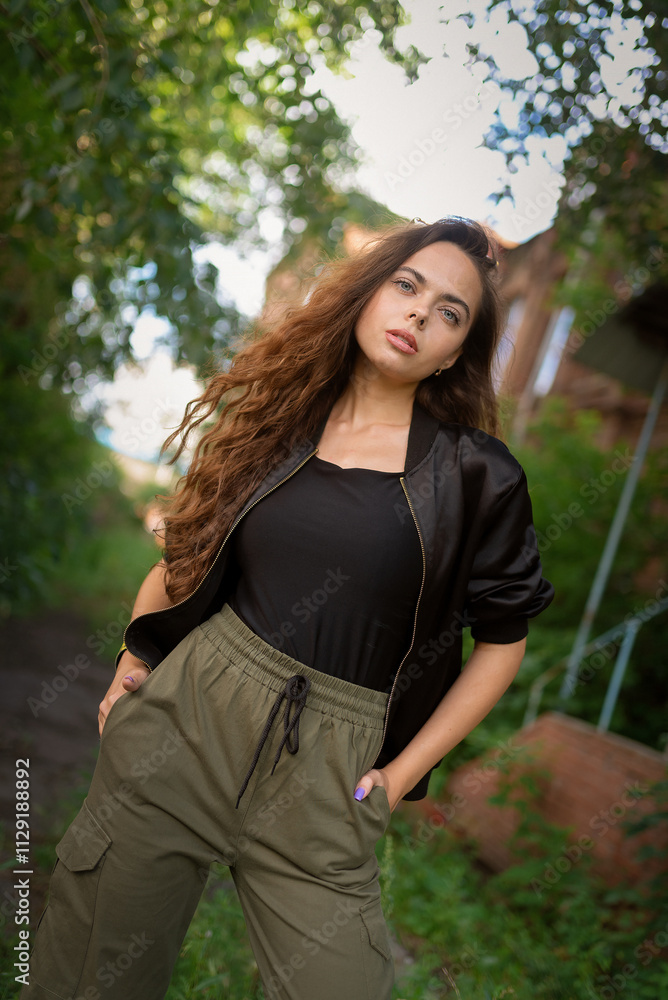 Beautiful young woman posing outdoors near an old brick building.. Beautiful young woman posing outdoors near an old brick building..