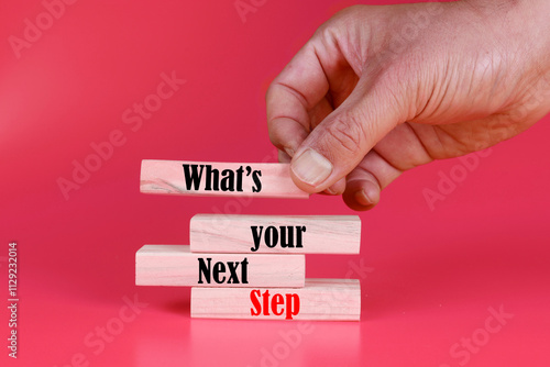 What is your next step symbol. Wooden blocks with words What is your next step. Businessman hand. Beautiful pink background. Business concept. Cop photo