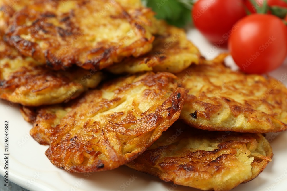 Delicious potato pancakes, tomatoes and parsley on plate, closeup Delicious potato pancakes, tomatoes and parsley on plate, closeup