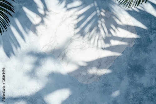 Marble texture on blue background with palm leaf shadows.