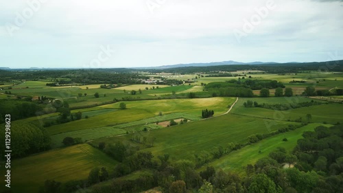 Lush farm fields against Girona town on nice summer day
