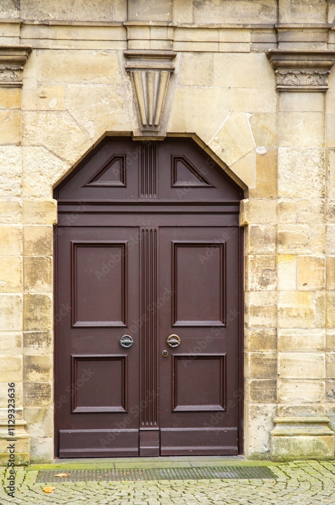 Elegant brown double door enhancing a stone wall facade Elegant brown double door enhancing a stone wall facade