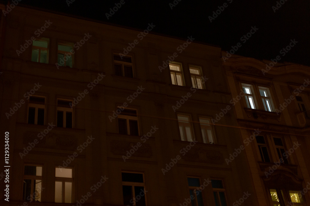 A large building that features numerous windows shines brightly and is beautifully illuminated during the night hours after sunset A large building that features numerous windows shines brightly and is beautifully illuminated during the night hours after sunset