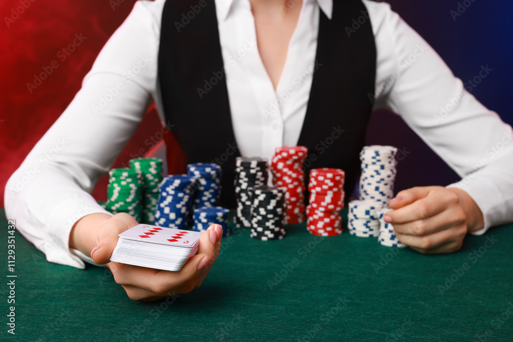 Professional croupier with casino chips and playing cards at gambling table on color background with smoke, closeup Professional croupier with casino chips and playing cards at gambling table on color background with smoke, closeup