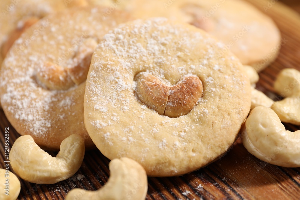 Tasty cashew cookies with powdered sugar on wooden board, closeup Tasty cashew cookies with powdered sugar on wooden board, closeup