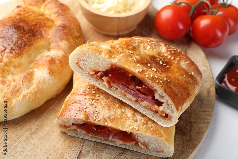 Pieces of fresh calzone pizza on wooden table, closeup Pieces of fresh calzone pizza on wooden table, closeup