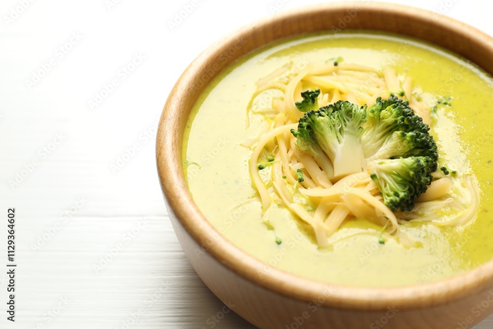 Delicious broccoli cream soup in bowl on white wooden table, closeup. Space for text Delicious broccoli cream soup in bowl on white wooden table, closeup. Space for text