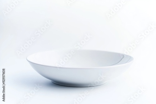 A white ceramic bowl sits on a table with a simple, clean design