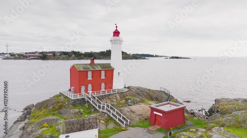 Victoria, British Columbia, Canada. November 02, 2024: Aerial view of the iconic Fisgard Lighthouse on Vancouver Island, surrounded by rocky shores and the vast ocean under a cloudy sky photo