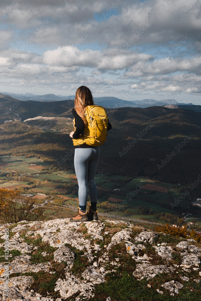 Young woman tourism in nature with a mountain landscape, contemplating the views from a mountain in Euskadi Young woman tourism in nature with a mountain landscape, contemplating the views from a mountain in Euskadi