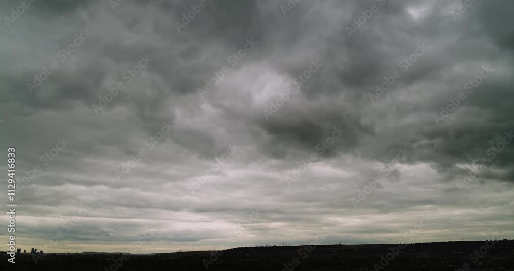 Timelapse of wide angle view of impressive grey overcast sky with clouds moving toward the camera and low dark horizon Timelapse of wide angle view of impressive grey overcast sky with clouds moving toward the camera and low dark horizon