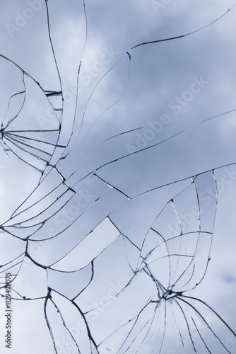 broken glass window with cracks and lines background reflecting the blue sky