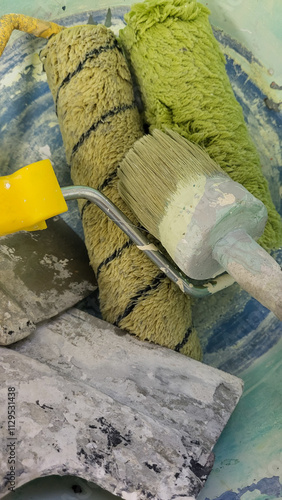 A bowl full of paint brushes and rollers