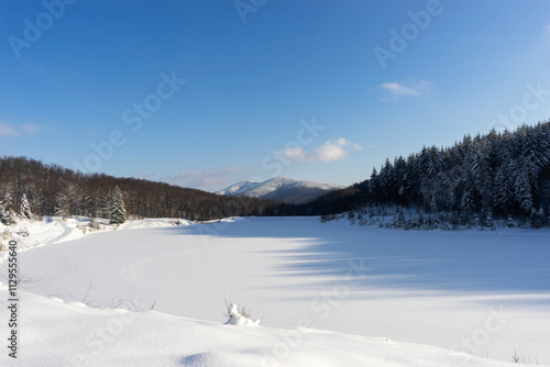 A snowy mountain lake in winter with a blue sky