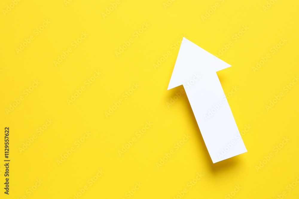 Paper arrow on color background, top view