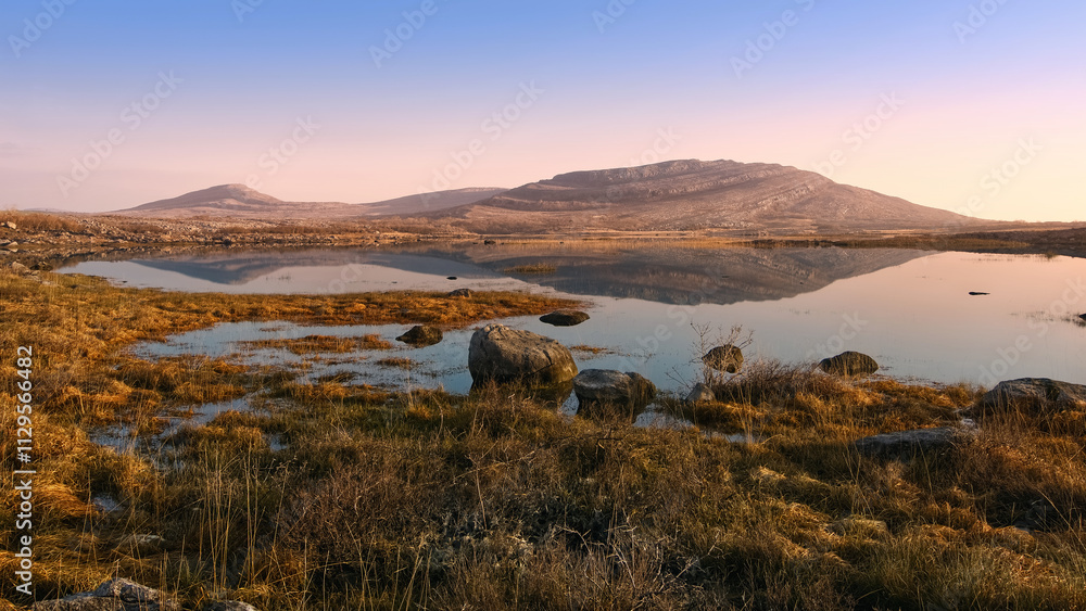 Beautiful sunrise landscape scenery of Mullaghmore mountain reflected in Lake at Burren National Park in county Clare, Ireland, nature background