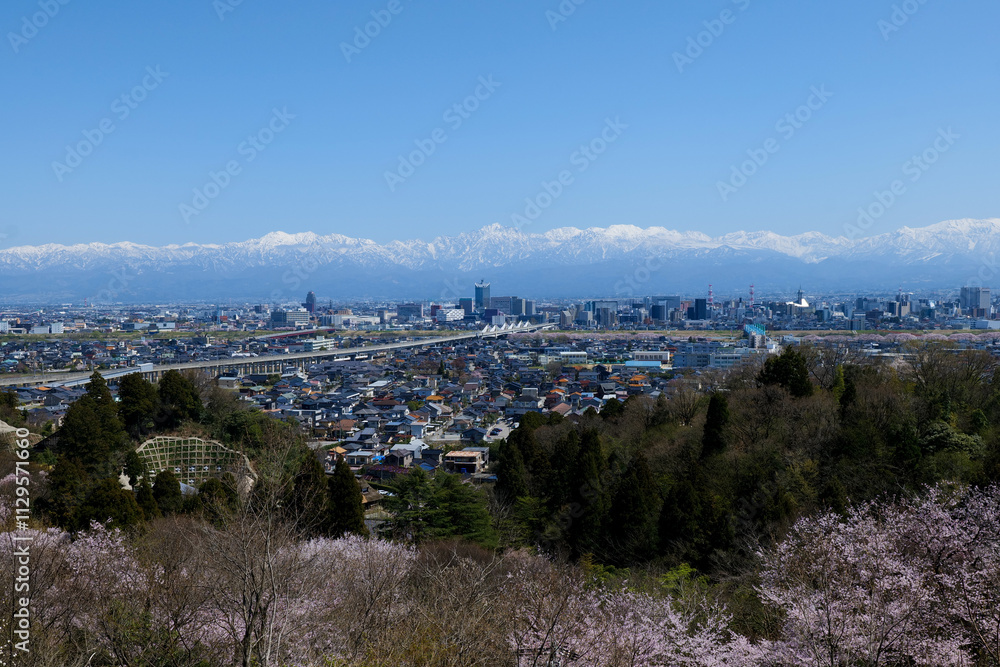 Obraz premium 呉羽山展望台から残雪の北アルプスと富山市街地パノラマ