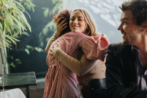 Принти на полотні Two friends share a heartfelt hug at a cafe, exuding warmth and happiness