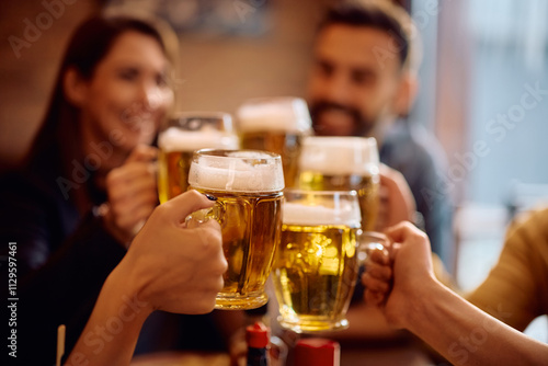 Close up of people toasting with beer glasses.