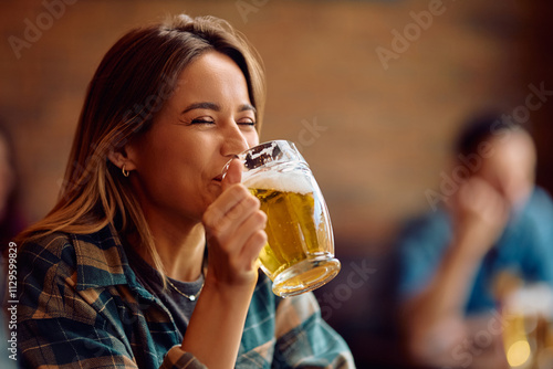 Cuadro en lienzo Happy woman drinking beer in bar.
