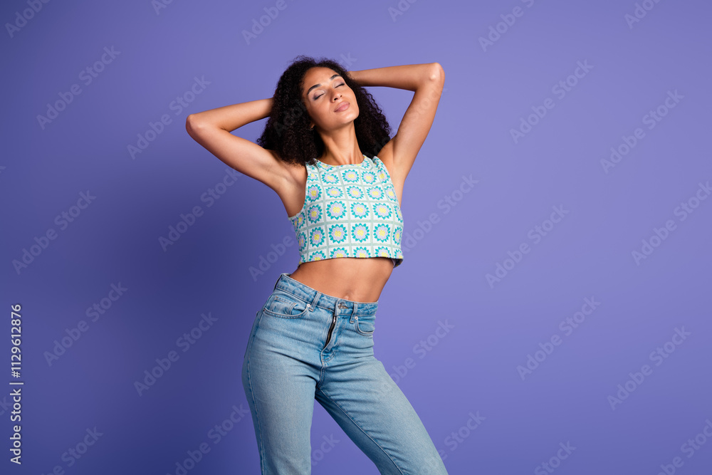 Confident young woman in trendy summer top standing against a vibrant purple backdrop expressing happiness and style. Confident young woman in trendy summer top standing against a vibrant purple backdrop expressing happiness and style.