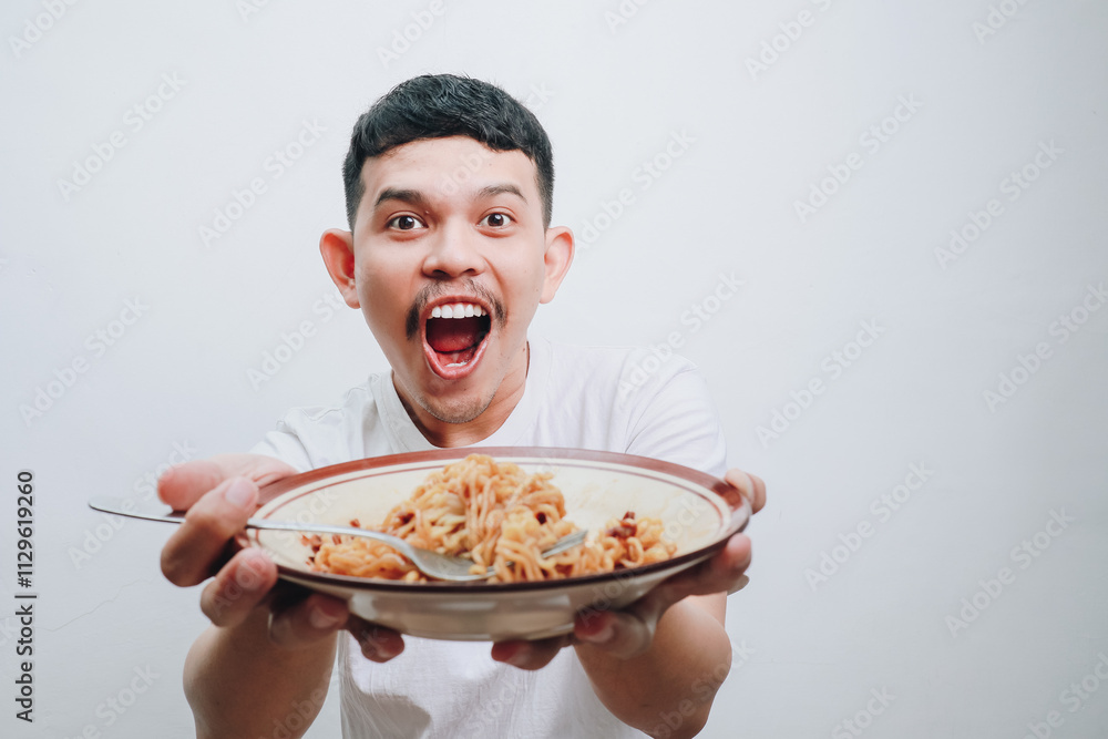 Excited Young Man Joyfully Holding a Plate of Delicious Noodles with a Big Smile Excited Young Man Joyfully Holding a Plate of Delicious Noodles with a Big Smile