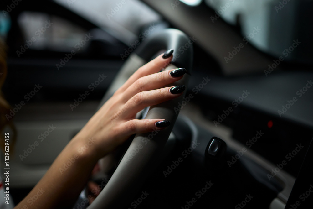 An up close image of a hand precisely adjusting a control in a luxurious automobile interior An up close image of a hand precisely adjusting a control in a luxurious automobile interior