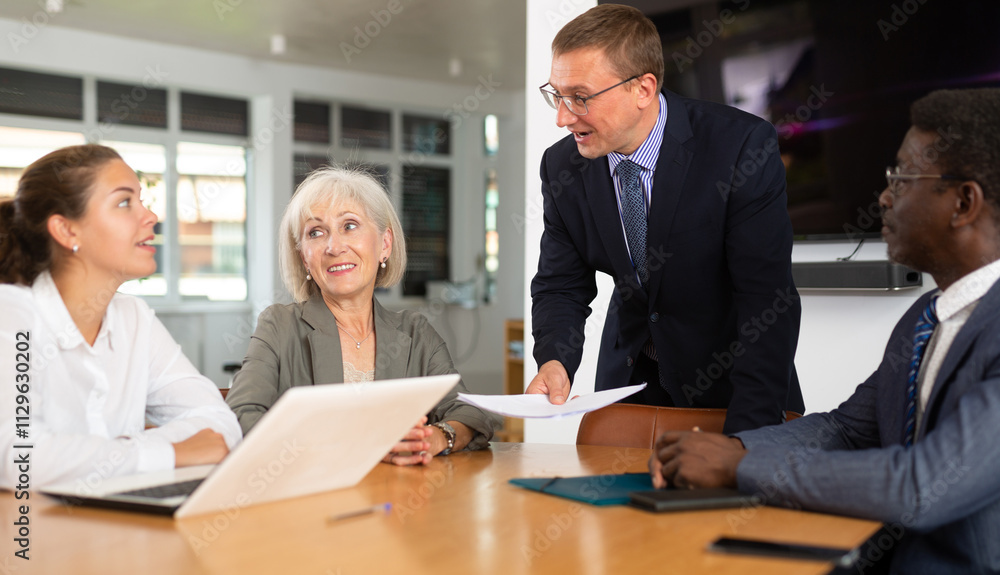 Group of different business people have discussion about work at table in office Group of different business people have discussion about work at table in office