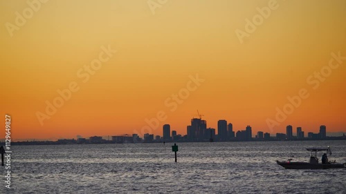 St Petersburg, Florida USA - Nov 02, 2024: A cruise ship pass St Petersburg Downtown city skyline and skyscraper at sun set seen from Apollo Beach Eg Simmons regional park landscape