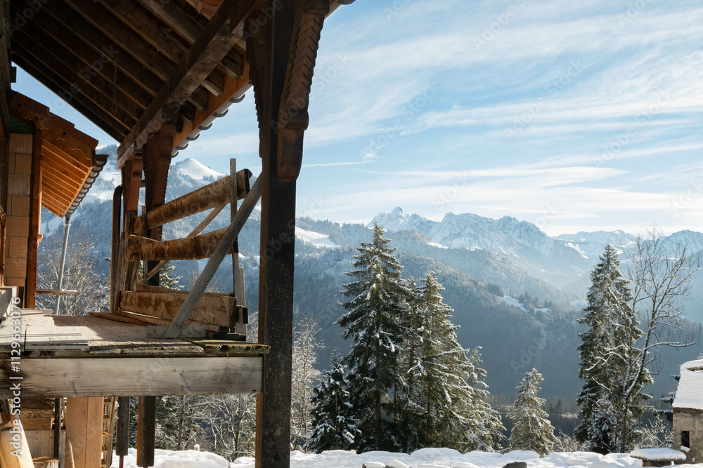 Swiss chalet balcony overlooking views of rural countryside mountainous Switzerland's snowy alps Swiss chalet balcony overlooking views of rural countryside mountainous Switzerland's snowy alps