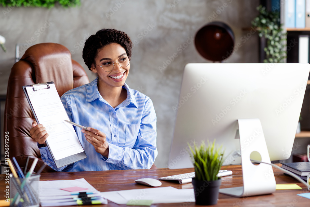 Confident businesswoman in formal attire presenting a document in a stylish office workspace Confident businesswoman in formal attire presenting a document in a stylish office workspace