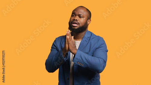 Obraz na plátně Friendly african american man puts hands together in apology gesture, asking for forgiveness