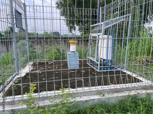 weather gauge in the field inside the fence photo