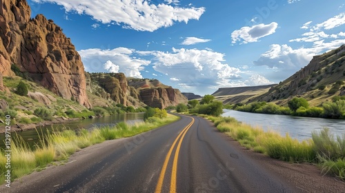 Scenic highway winding along a river canyon under a partly cloudy sky.