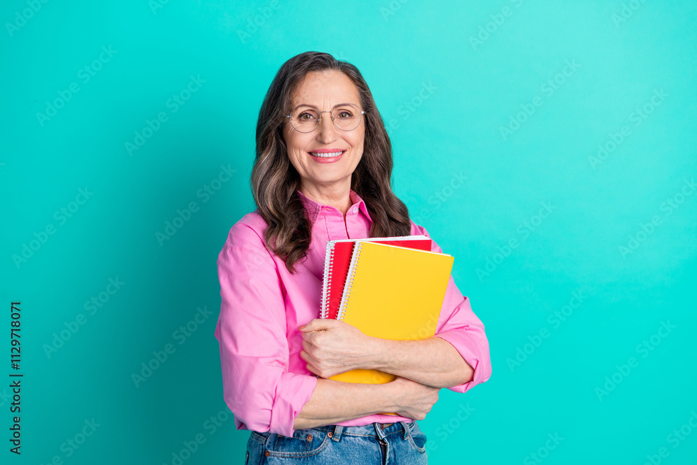 Photo of shiny attractive lady dressed pink shirt holding copybooks empty space isolated teal color background Photo of shiny attractive lady dressed pink shirt holding copybooks empty space isolated teal color background