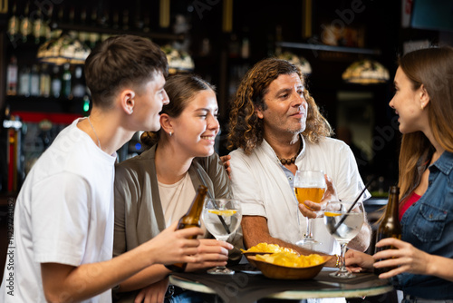 Happy friends drinking beer and chatting with each other in a restaurant