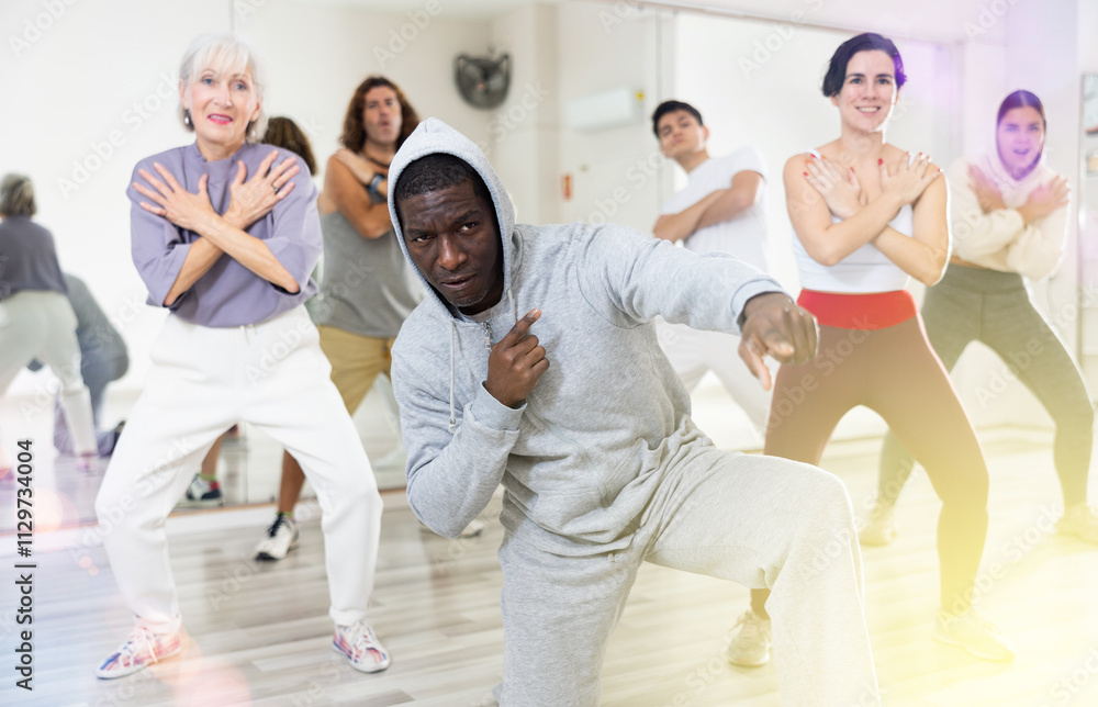 Happy african man learning new hip-hop dance in group dance lesson Happy african man learning new hip-hop dance in group dance lesson