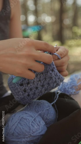 Close-up of women's hands knitting in nature