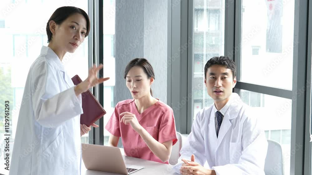 モニターを見ながら会議をする医師と看護師