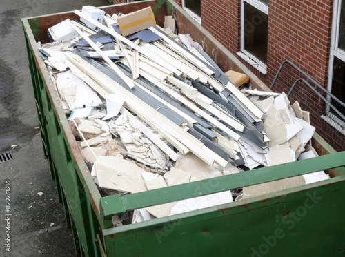 A high angle view of a skip filled with broken plasterboard and other demolition waste