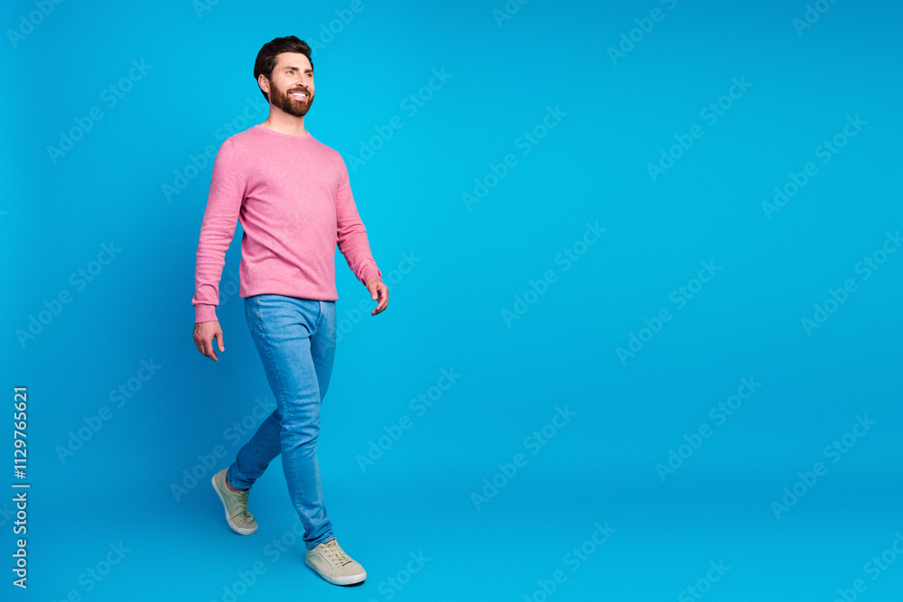 Confident man in casual fashion walking against a vibrant blue background Confident man in casual fashion walking against a vibrant blue background