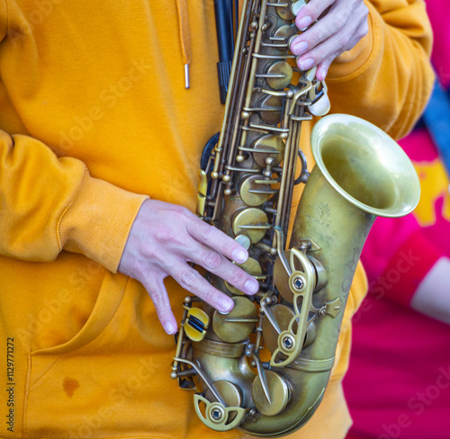 a saxophone rests quietly on a table. Soft light falls on it, outlining its graceful curves