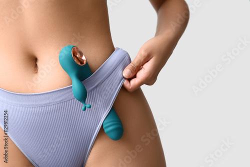 Cuadro en lienzo Beautiful young woman in sexy underwear with vibrator on grey background, closeu