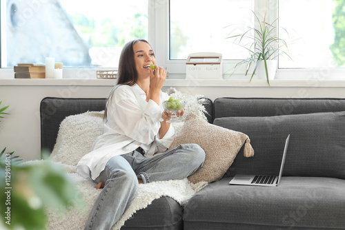 Young woman eating green gr...