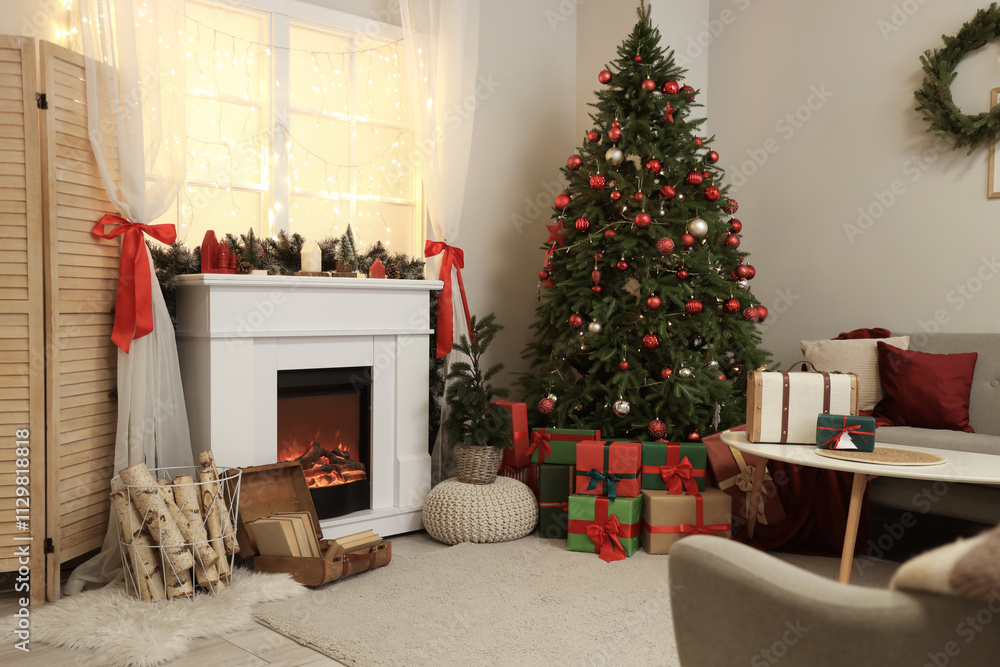 Fototapeta premium Stylish interior of living room with beautiful fireplace, folding screen, Christmas tree and presents