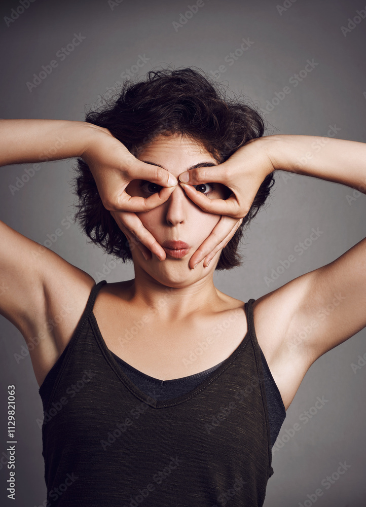 Circle on eyes, funny face and portrait of girl in studio for facial expression, excited and emoji reaction. Comic, humor and isolated woman with joke, silly pose and crazy on dark background