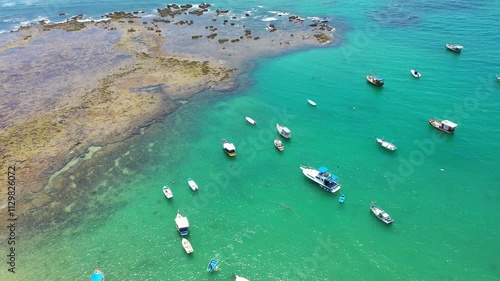 Fantastic aerial view of Praia do Forte beach with small boats turquoise waters and a cute village near Salvador. Praia do Forte, Bahia, Brazil 